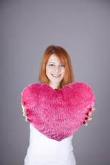 Portrait of red-haired girl with toy heart.