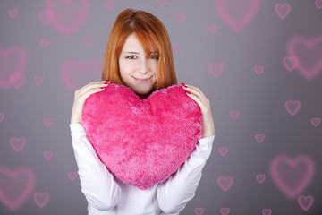 Portrait of red-haired girl with toy heart.