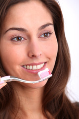 Closeup of beautiful woman brushing her teeth