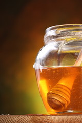 Pot of honey and wooden in it.