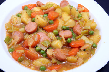 kartoffeleintopf mit bohnen auf weißen teller