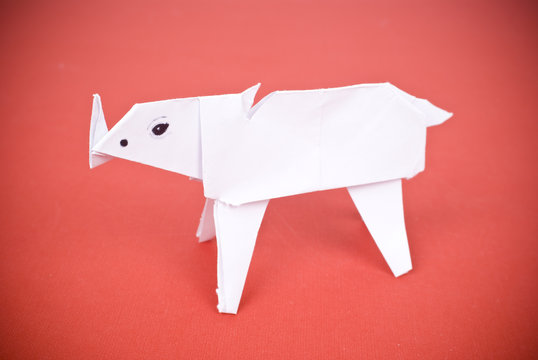 rhinoceros out of paper on a red background