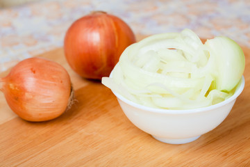 Raw whole and sliced onion on the cutting board