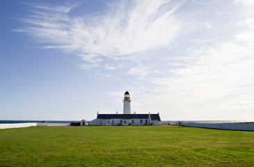 Fototapeta na wymiar Lighthouse with Cloudy sky and Green Grass