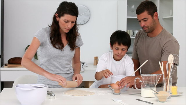 Cute family cooking biscuits in the kitchen