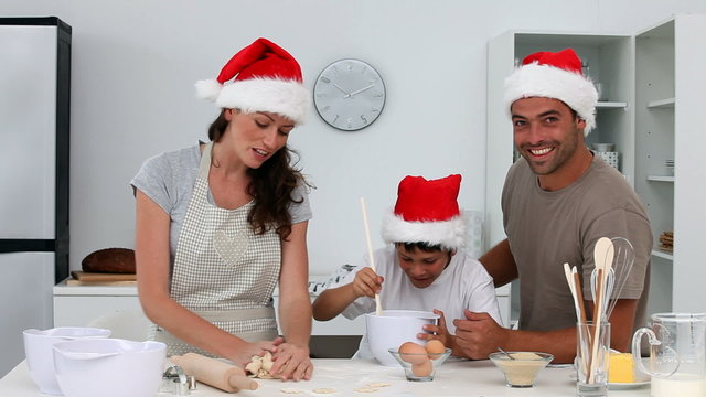 Proud dad cooking christmas cake with his family in the kitchen