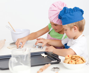 Adorable siblings cooking biscuits together in the kitchen