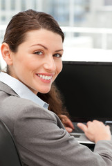 Rear view of a happy businesswoman working on her laptop