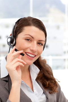 Beautiful businesswoman with headphones and smiling at camera