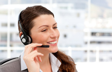 Pretty businesswoman with earpiece in her office