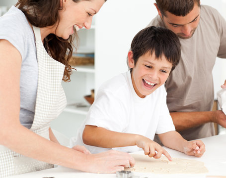 Cheerful family having fun while preparing biscuits together
