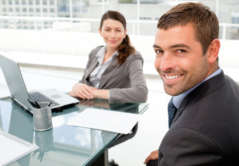 Cheerful business people working on a laptop during a meeting