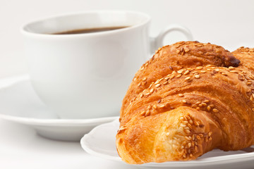 Breakfast: coffee and croissant with sesame seeds