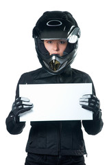 Woman in motorcycle clothing and helmet holding a white board