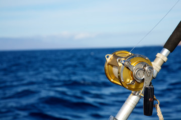 A fishing reel set against blue ocean