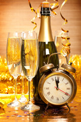 Happy New Year - Bottle of champagne, two glasses and alarm clock as a symbol of New Year's fun © digieye