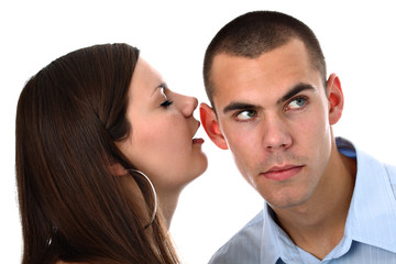 Girl whispers into her boyfriend's ear isolated on white