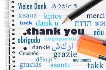Thank you in many different languages written on an open noteboo