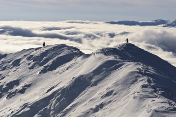 two climbers on a mountain top in winter