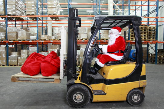 Santa Claus as a forklift operator at work in warehouse
