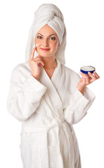 Woman in bathrobe is putting the cream