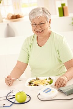 Happy senior woman eating salad