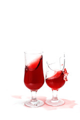 two glasses with wine and drops ,one  glass is broken