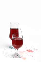 two glasses with wine and drops  .one  glass is broken