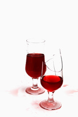 two glasses with wine and drops  .one  glass is broken
