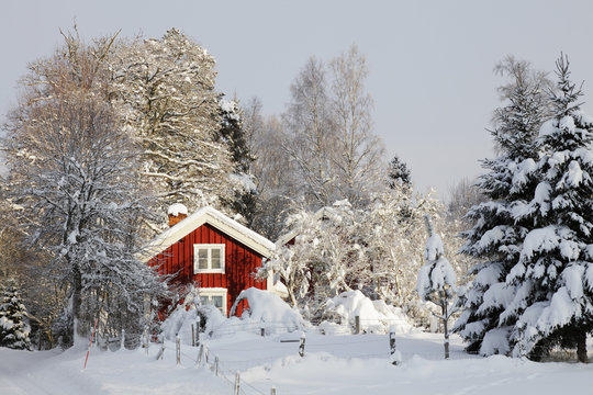 red cottage, snow and ice in sweden