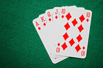 Royal straight flush poker cards on a green table background