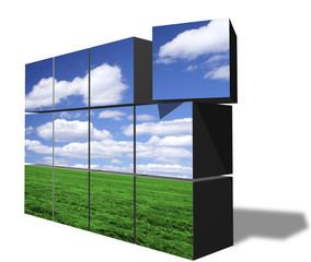 Stacked blocks forming image of clear sky over green field