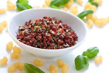 sun-dried tomatoes with basil and salt in a white bowl