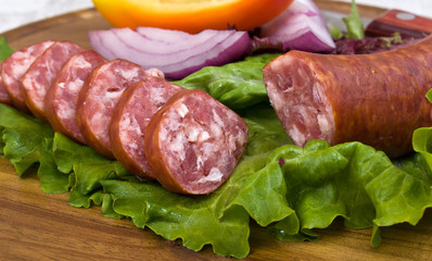 Breakfast close-up. Slices of sausage on the wooden plate with k