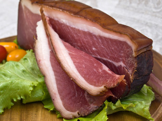 Breakfast close-up. Slices of bacon on the wooden plate with kni