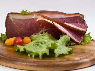 Breakfast close-up. Slices of bacon on the wooden plate with kni