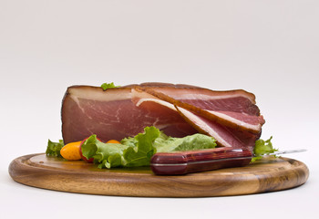 Breakfast close-up. Slices of bacon on the wooden plate with kni