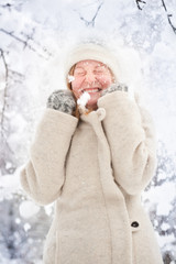 Winterliches Portrait einer jungen blonden Frau im Schnee