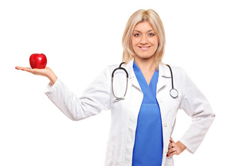 Female medical doctor with stethoscope holding a red apple