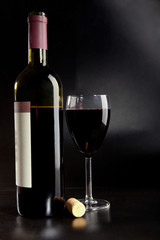 Bottle of red wine with a glass