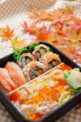 巻き寿司のお弁当と紅葉したモミジ
