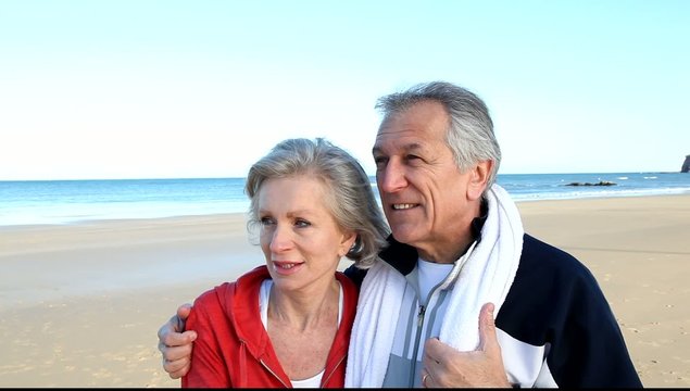 Senior couple at the beach in fitness outfit