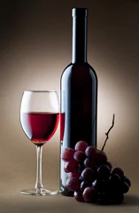 Wall murals Wine glass of red wine with bottle and cluster