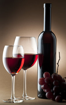 glass of red wine with bottle and cluster