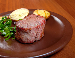 Grilled beef on white plate with potatoes