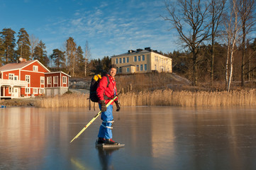 A male ice skater on a frozen lake