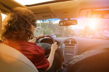 Beautiful woman driving a luxury car, rear view.