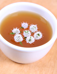 White bowl of green tea with mint twigs