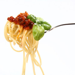 Spaghetti bolognese with basil leaves on a fork