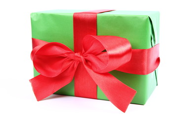 Gift in green wrapping with a red bow on white background